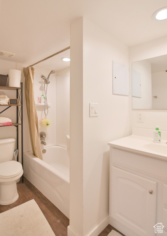 Full bath featuring wood finished floors, vanity, shower / bathtub combination with curtain, and recessed lighting