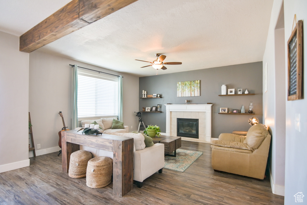 Living room featuring wood finished floors, a fireplace, and a ceiling fan