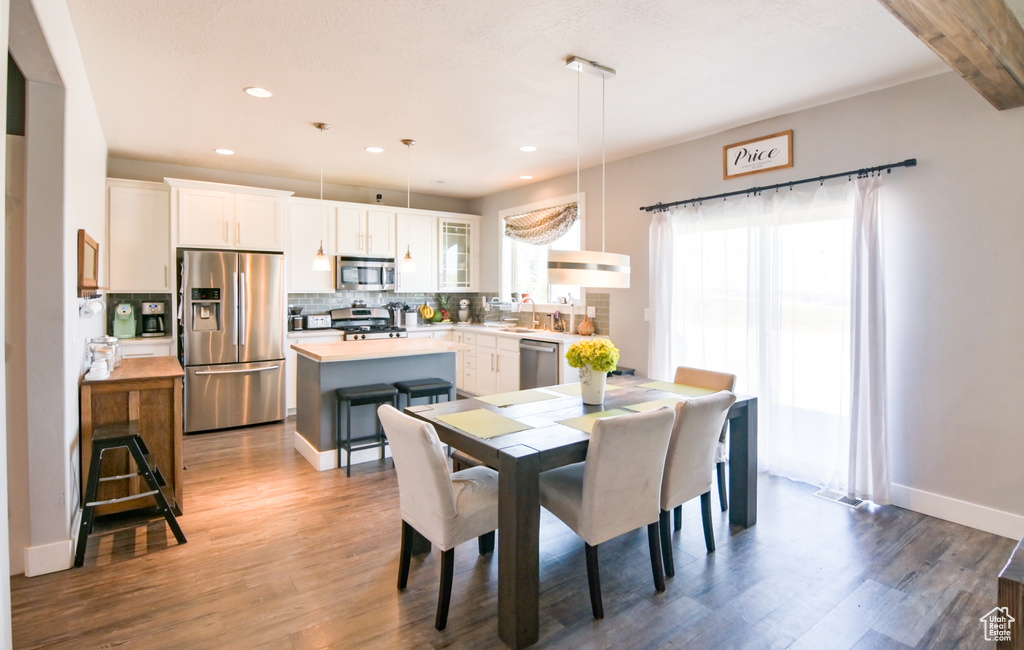 Dining space with wood finished floors and recessed lighting