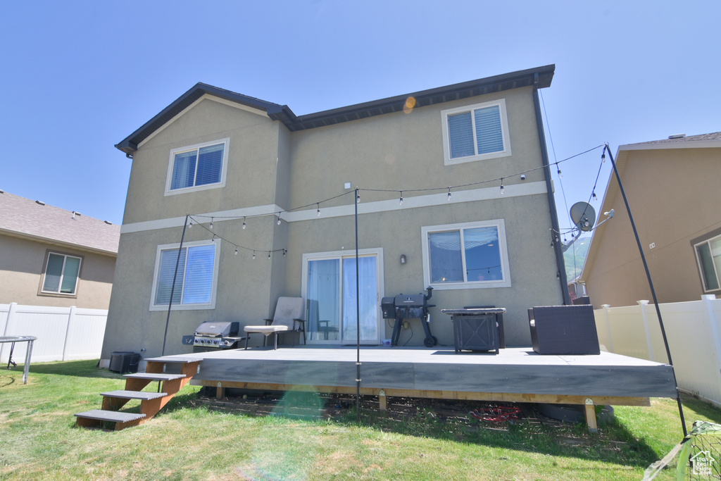 Rear view of house with a wooden deck and stucco siding