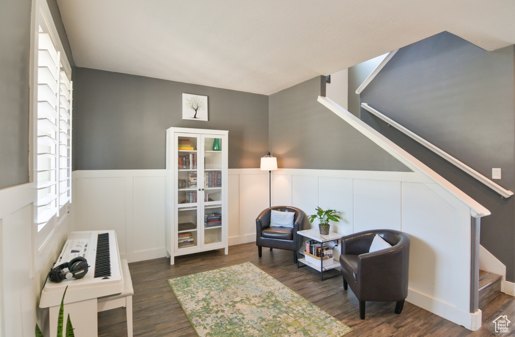 Living area featuring stairway, a wainscoted wall, wood finished floors, and a decorative wall