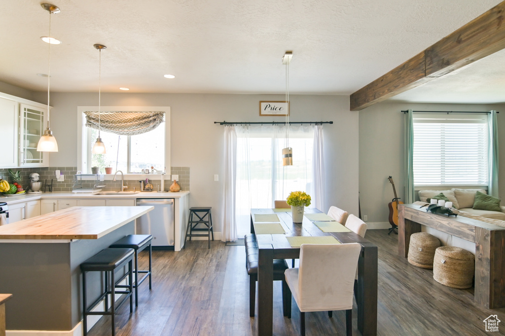 Dining room featuring dark wood-type flooring, recessed lighting, and beamed ceiling