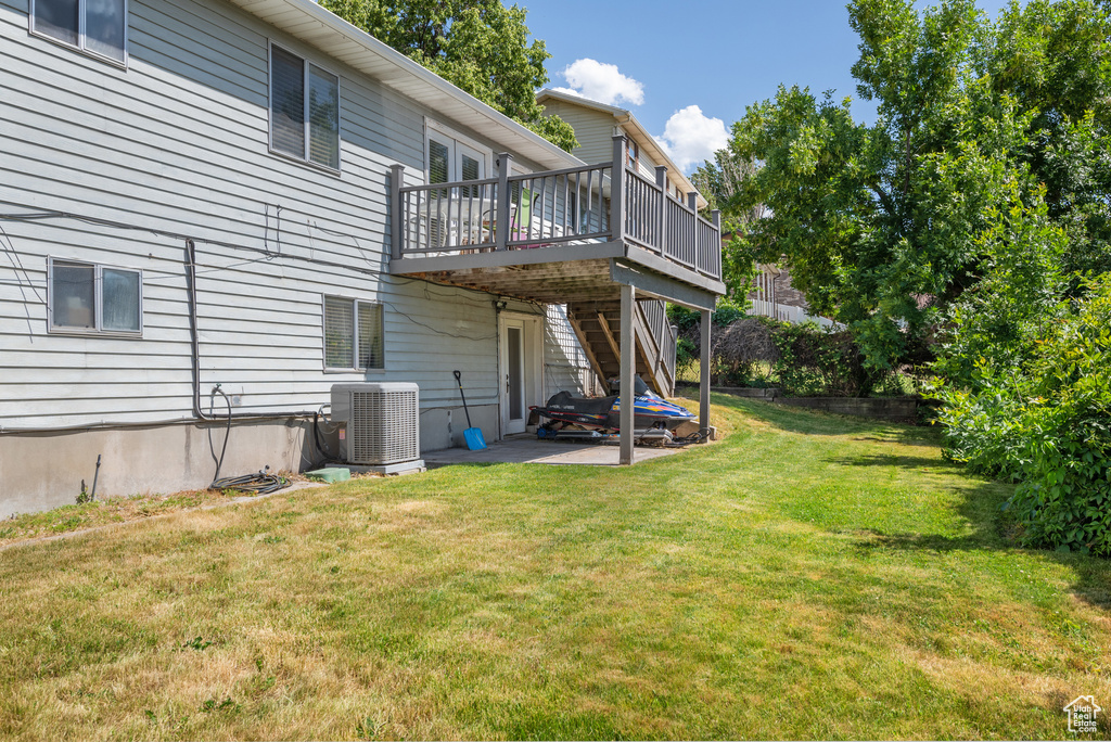 Back of house featuring a wooden deck, a patio area, a yard, stairway, and french doors