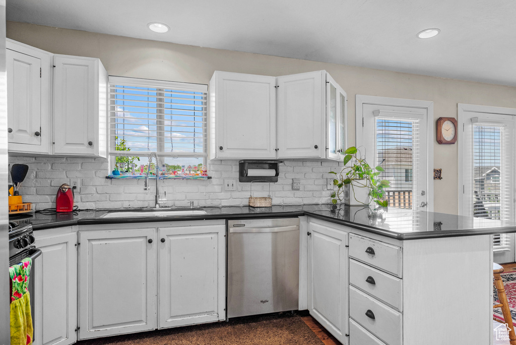 Kitchen featuring dishwasher, dark countertops, a peninsula, black range with gas stovetop, and recessed lighting