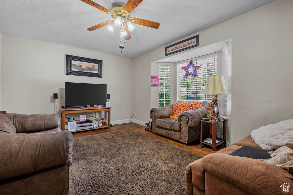 Living area with wood finished floors and ceiling fan