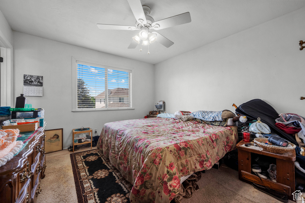 Carpeted bedroom featuring ceiling fan