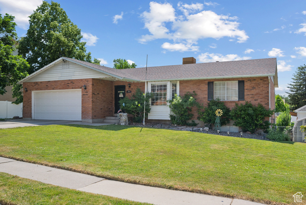 Ranch-style home with a garage, brick siding, and driveway