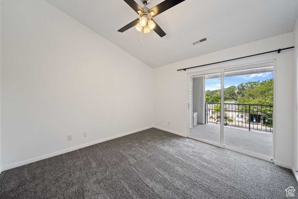 Empty room with vaulted ceiling, carpet, and ceiling fan