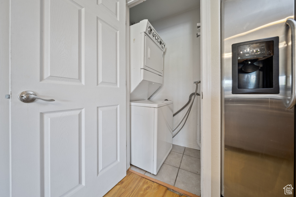 Laundry area featuring stacked washer / dryer and light tile patterned floors