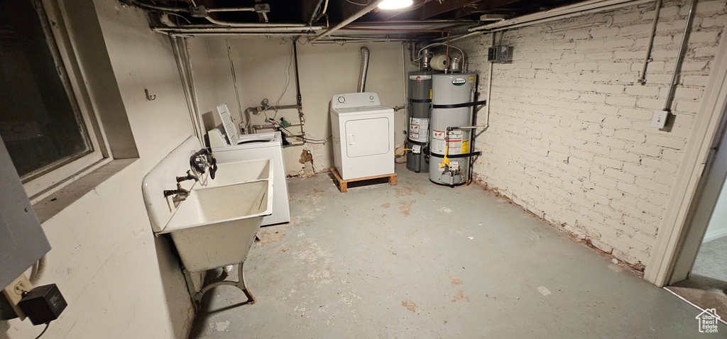 Unfinished below grade area featuring washer / clothes dryer and water heater