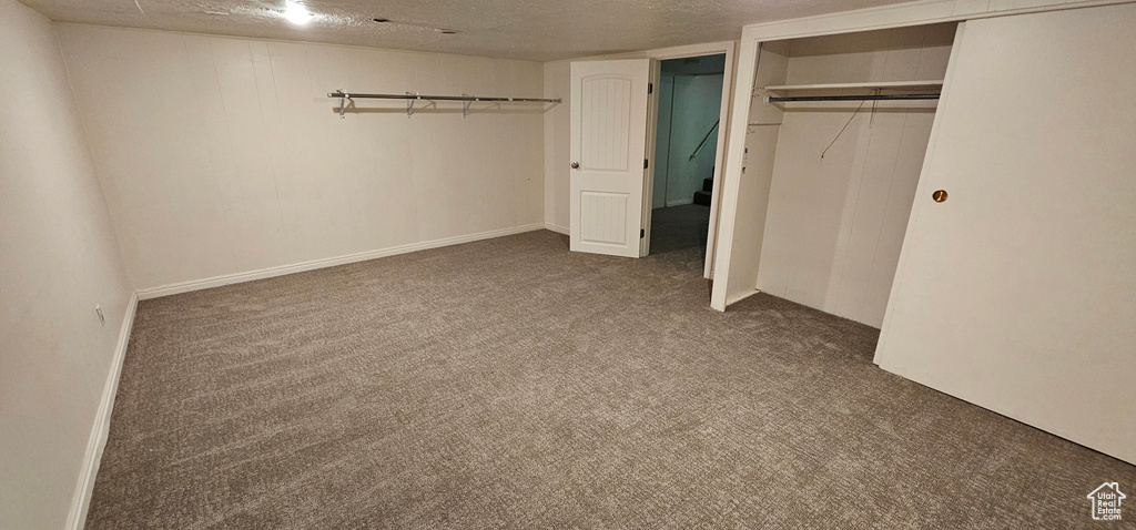 Unfurnished bedroom with carpet, a textured ceiling, and a closet