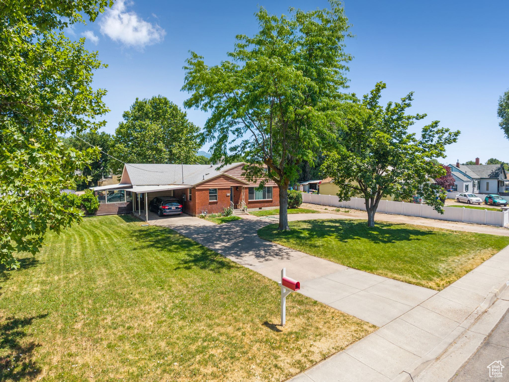 Ranch-style house featuring an attached carport, concrete driveway, and brick siding
