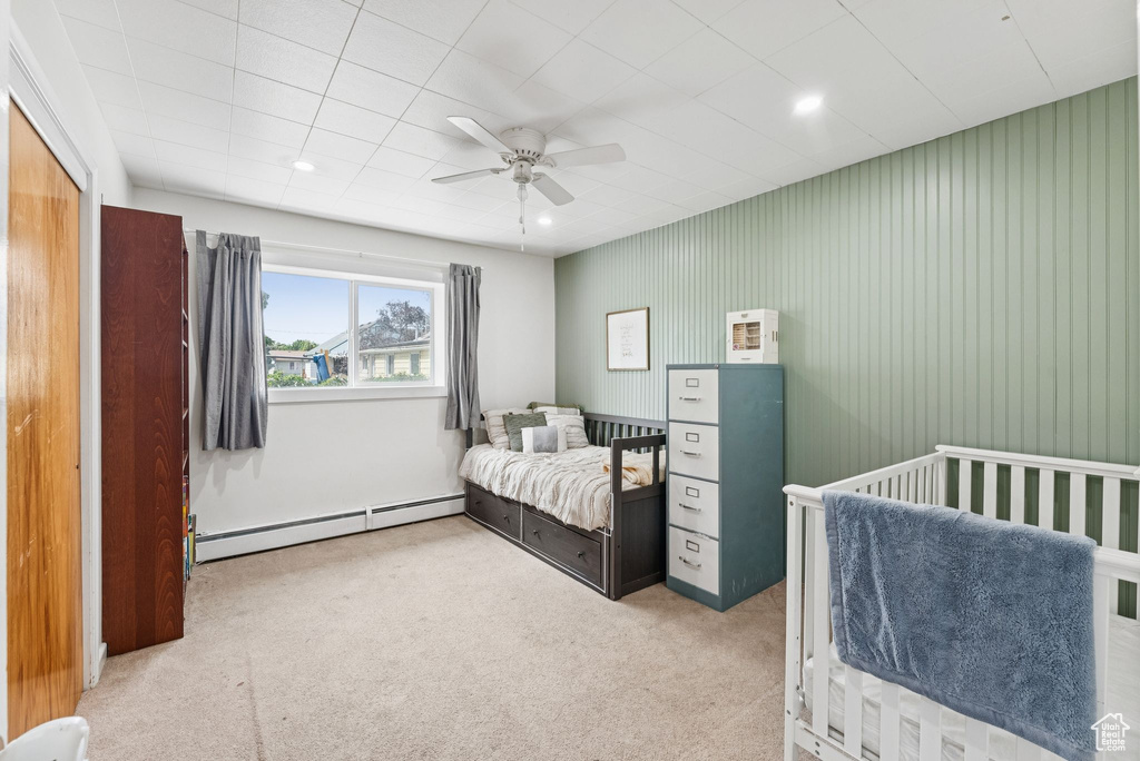 Carpeted bedroom featuring a baseboard radiator, a ceiling fan, and recessed lighting