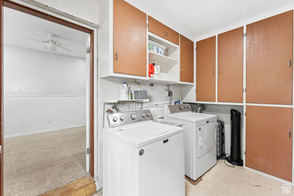 Laundry area featuring independent washer and dryer, ceiling fan, and cabinet space