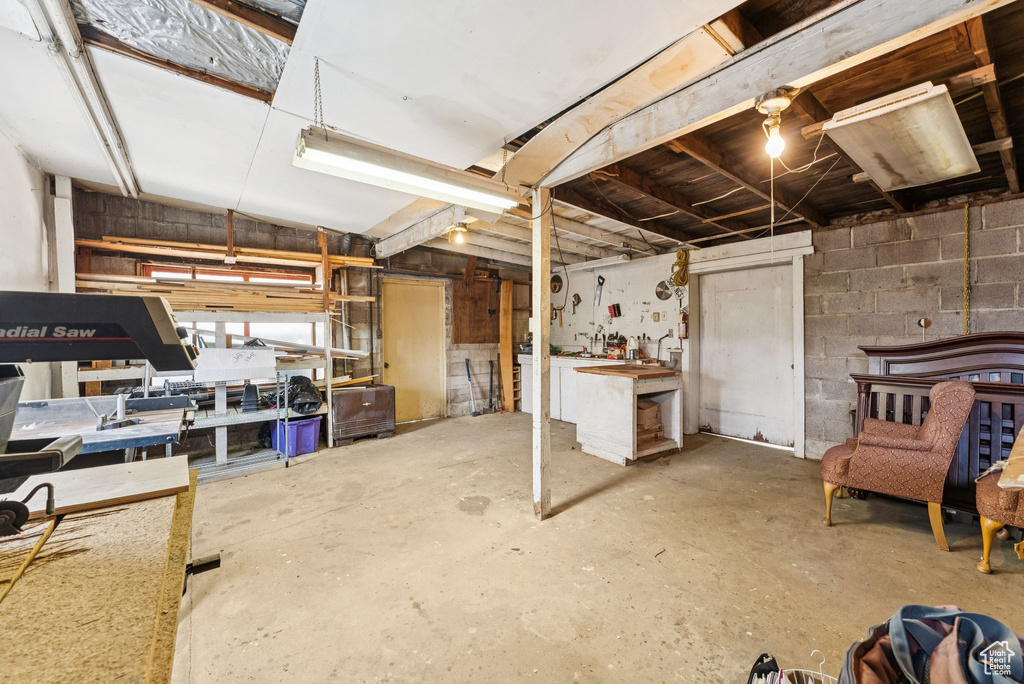 Below grade area featuring a workshop area and concrete block wall