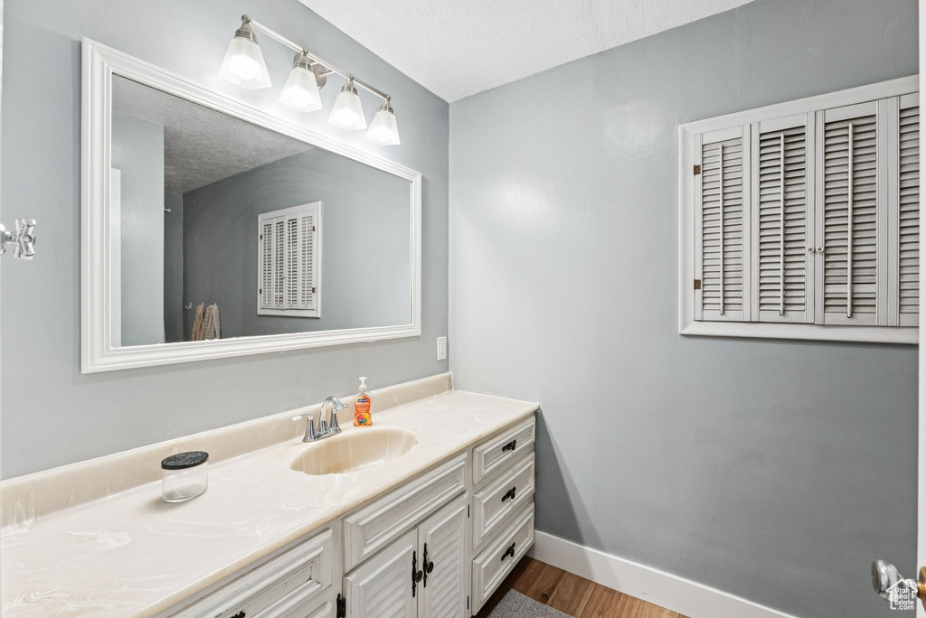Bathroom featuring vanity and wood finished floors