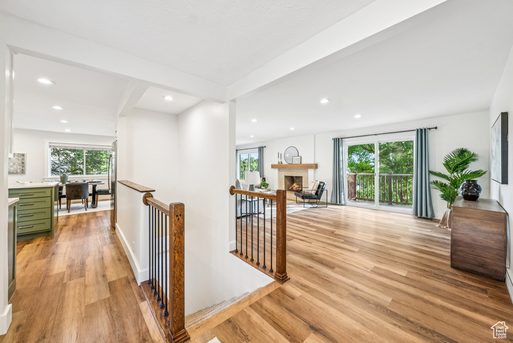 Corridor featuring an upstairs landing, light wood-style flooring, and recessed lighting