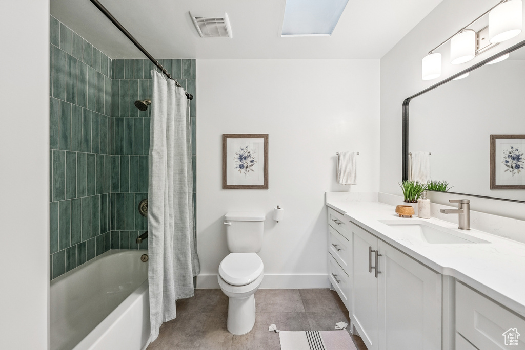 Bathroom with vanity, shower / bath combo with shower curtain, and tile patterned flooring