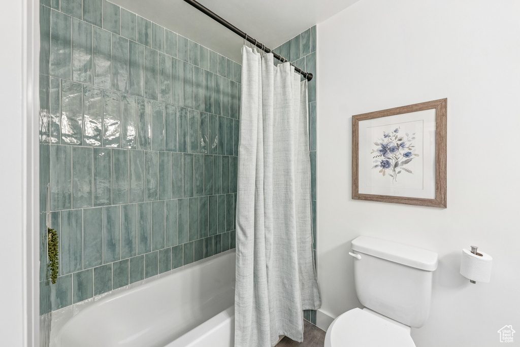 Bathroom featuring toilet and shower / tub combo