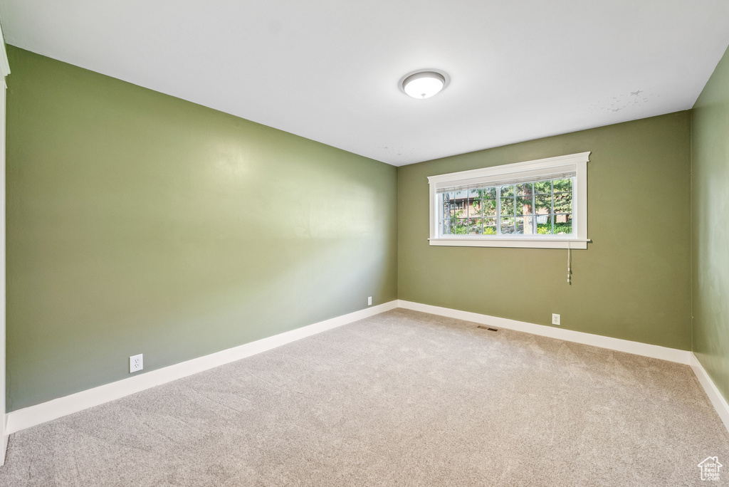 Empty room with carpet flooring and baseboards