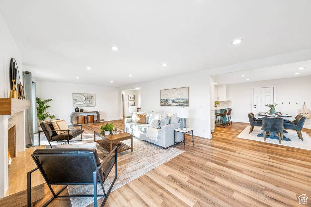 Living area with light wood-style floors, recessed lighting, and a premium fireplace