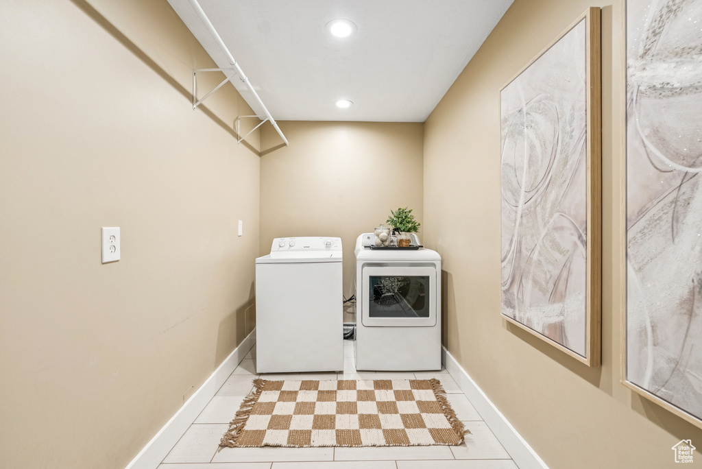 Washroom with independent washer and dryer, tile patterned floors, and recessed lighting