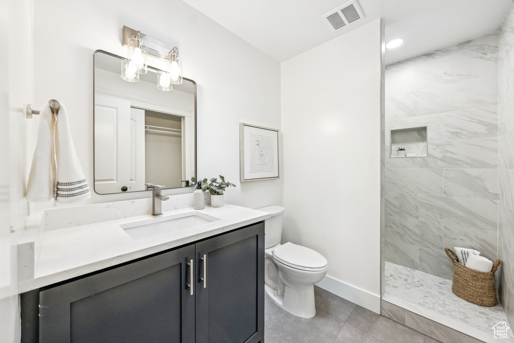 Bathroom with vanity, a walk in shower, and tile patterned floors