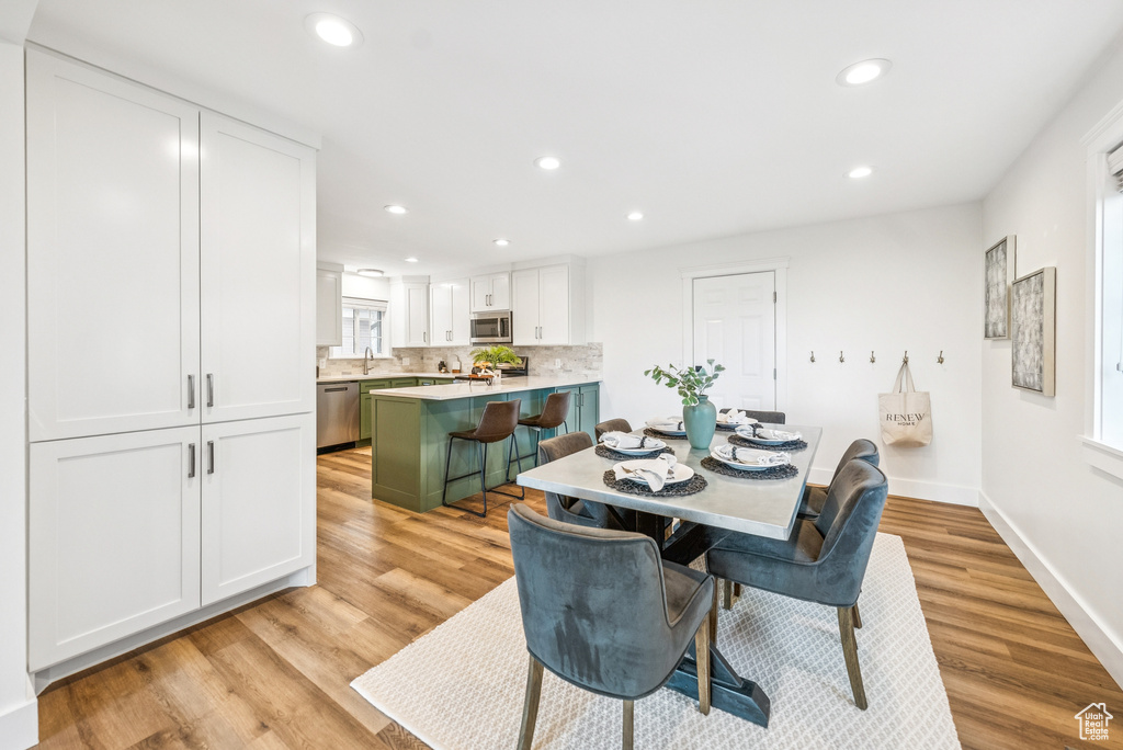 Dining area with recessed lighting and light wood finished floors