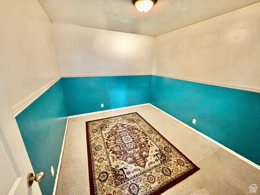 Carpeted spare room featuring baseboards