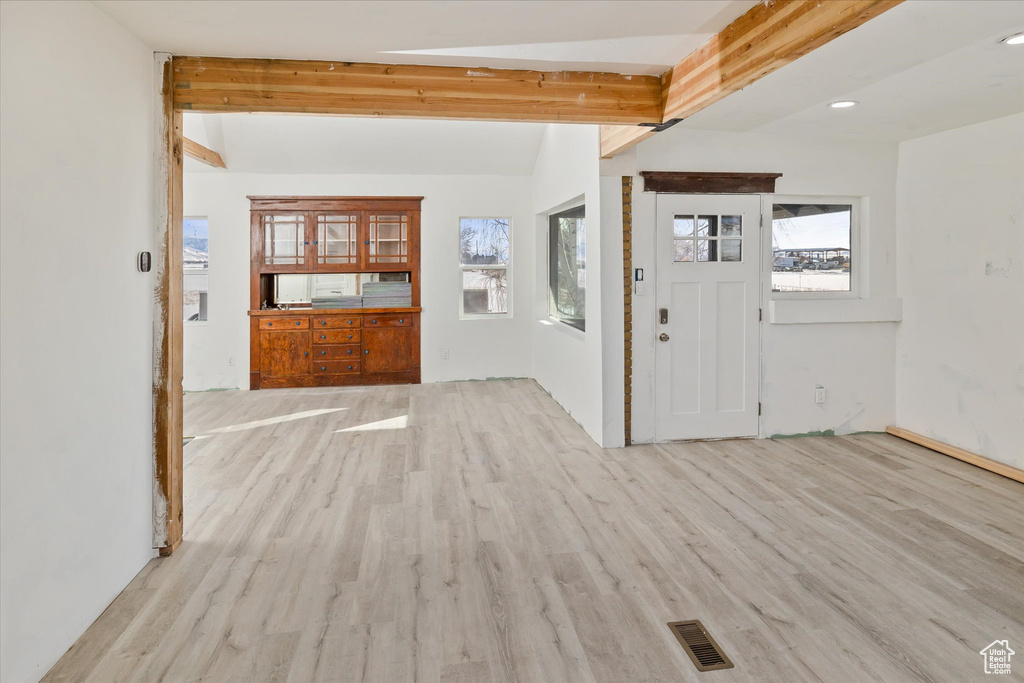 Foyer with beamed ceiling and light wood-style flooring