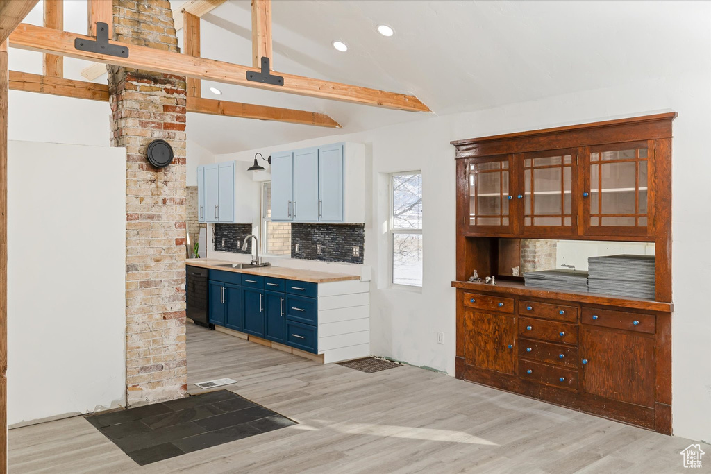 Kitchen featuring blue cabinetry, light wood-type flooring, tasteful backsplash, light countertops, and recessed lighting