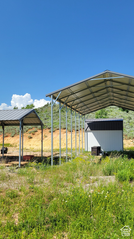 View of car parking featuring a storage unit and a detached carport