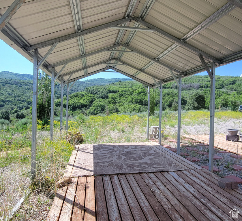 Wooden terrace featuring a view of trees and a mountain view