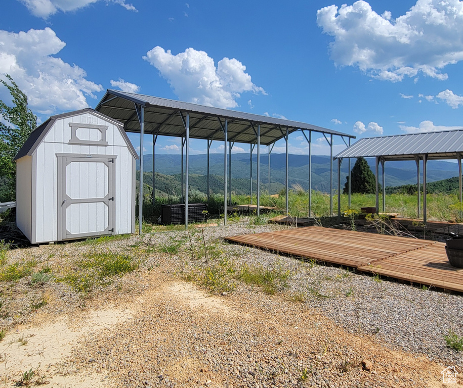 View of yard featuring a storage shed, a mountain view, and a carport
