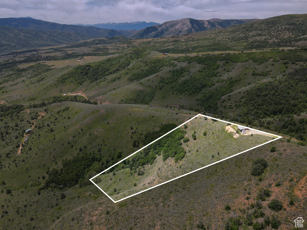 Aerial overview of property\'s location with a mountainous background and property boundaries highlighted