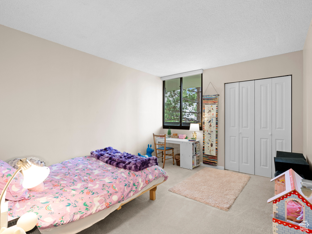 Bedroom featuring carpet flooring and a closet