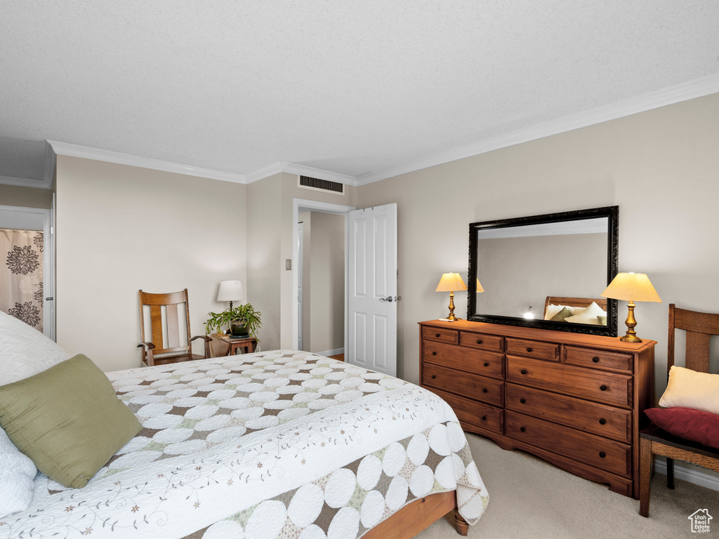 Bedroom with ornamental molding and carpet