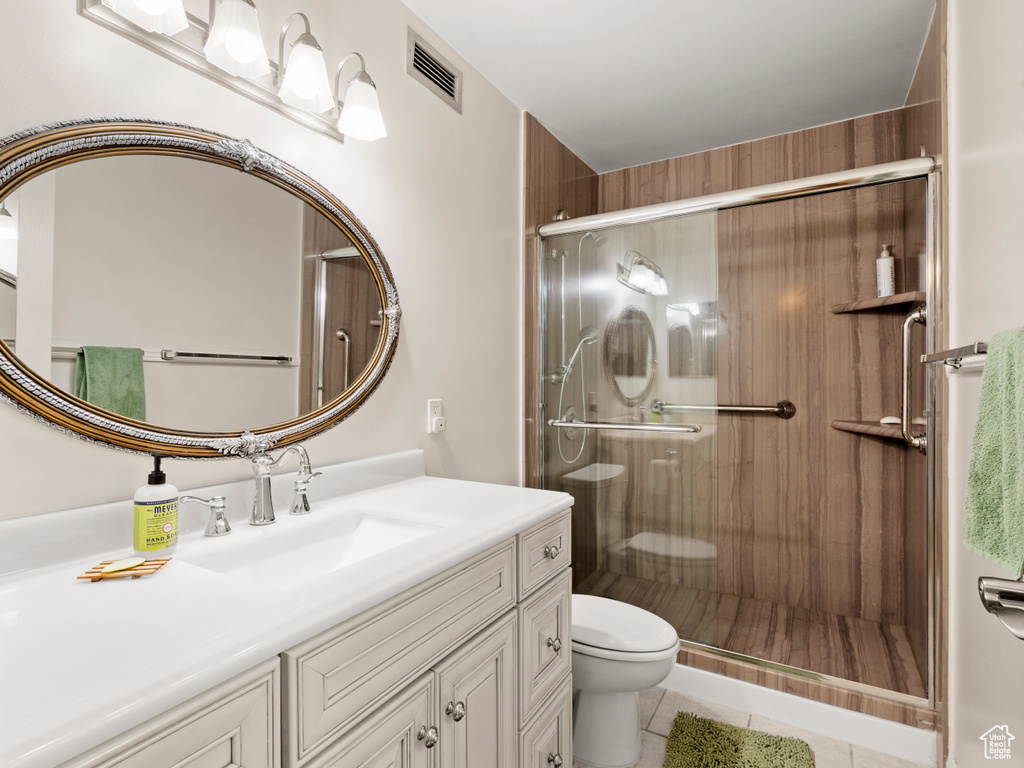 Bathroom with tile patterned flooring, vanity, and a stall shower