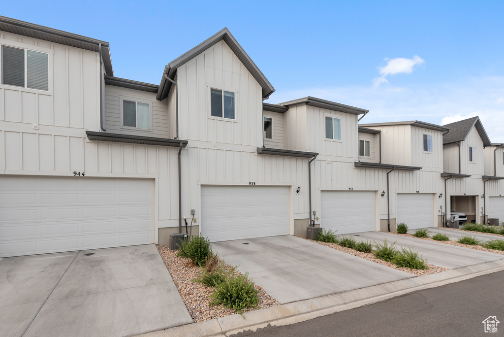 View of property featuring an attached garage, board and batten siding, and driveway