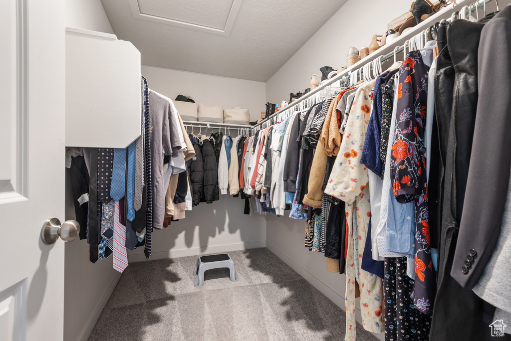 Spacious closet with attic access and carpet flooring