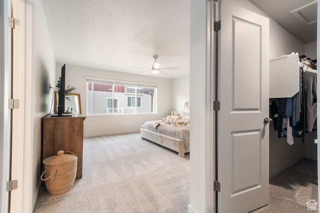 Carpeted bedroom with a textured ceiling and ceiling fan