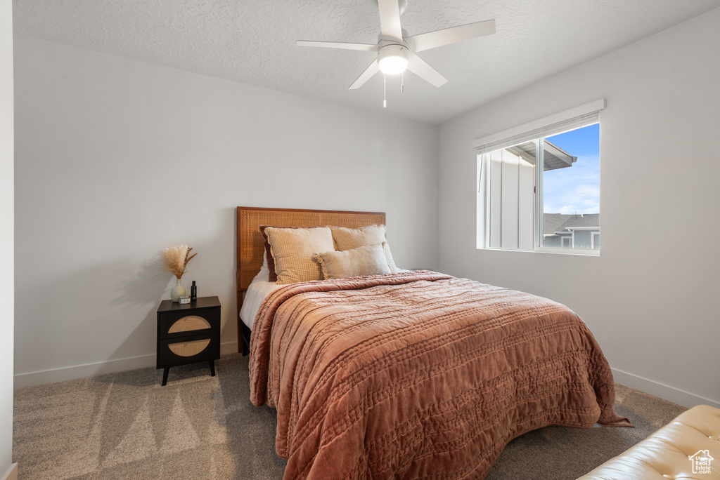 Carpeted bedroom featuring baseboards and a ceiling fan