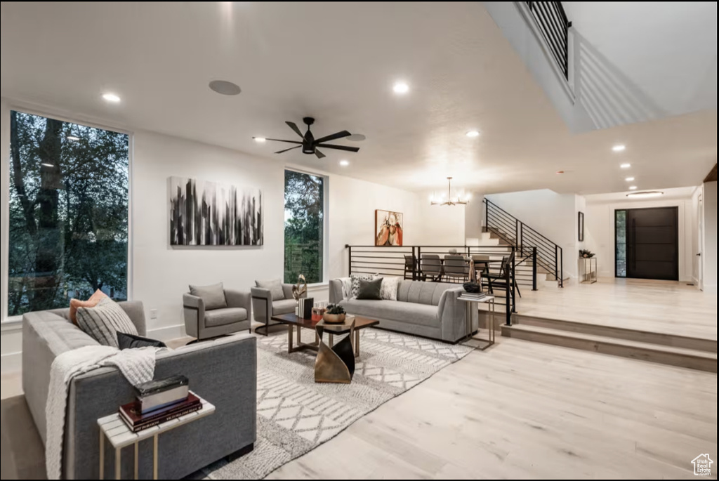 Living room with recessed lighting, a chandelier, light wood-type flooring, and ceiling fan