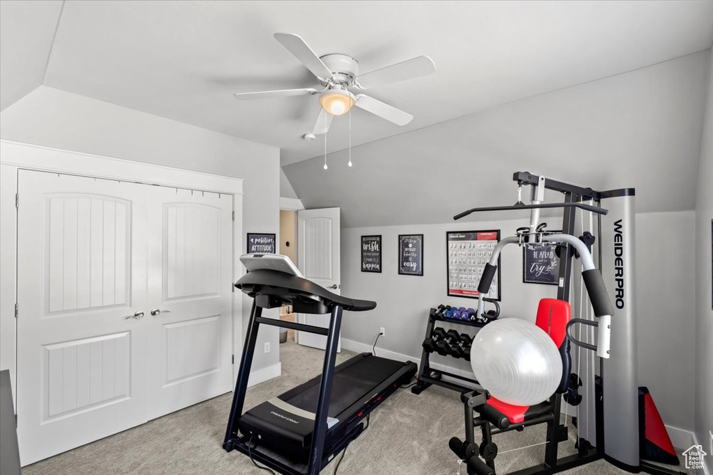 Workout room featuring lofted ceiling, ceiling fan, and carpet