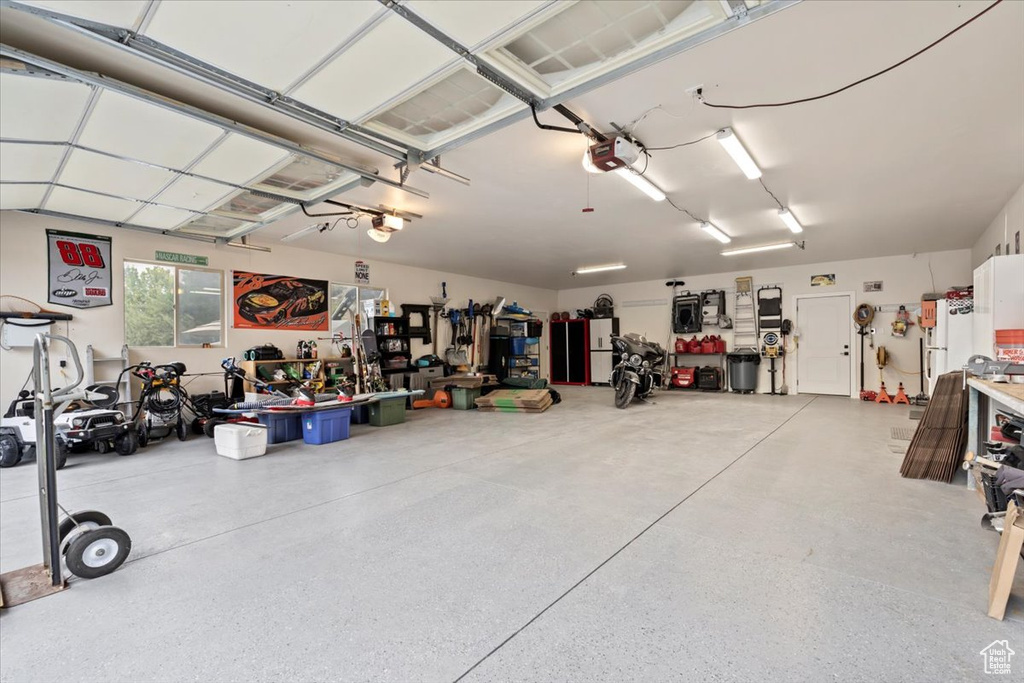 Garage featuring a garage door opener and a workshop area