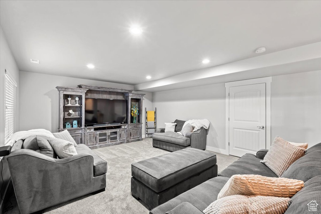 Living area with light colored carpet and recessed lighting