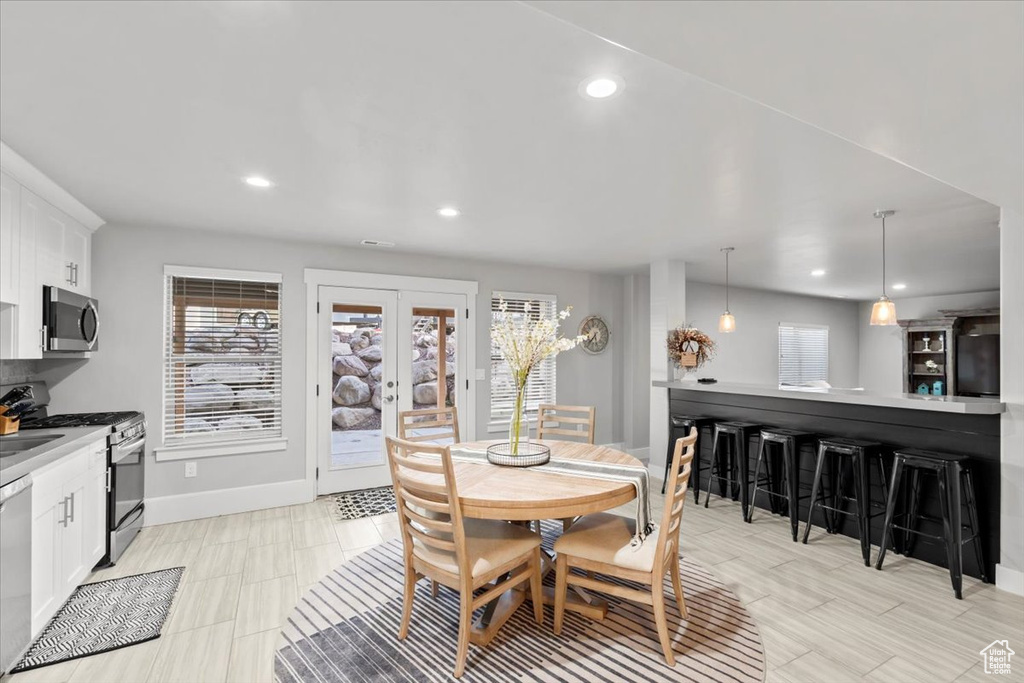 Dining room with healthy amount of natural light, recessed lighting, and french doors