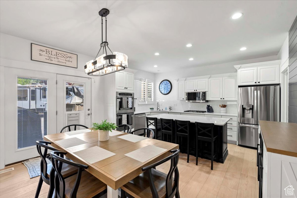 Dining area featuring recessed lighting, plenty of natural light, light wood-style floors, and a chandelier