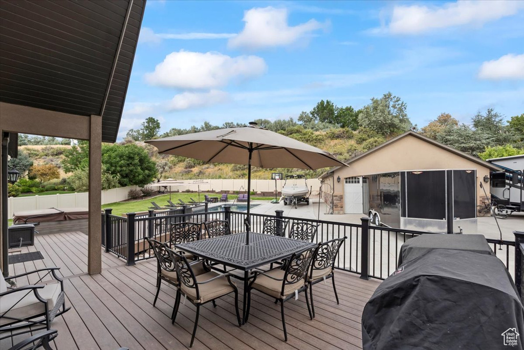 Wooden deck with outdoor dining space and a patio