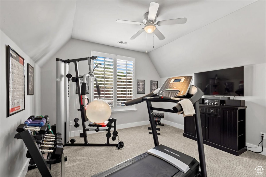 Workout area featuring vaulted ceiling, ceiling fan, and carpet floors